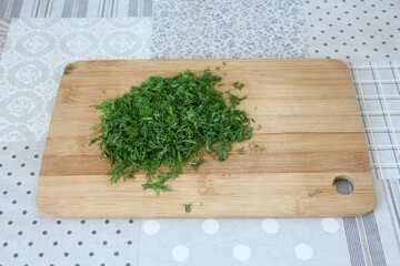 Chopped dill on the wooden cutting board