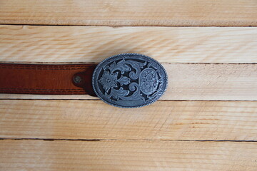 Fototapeta na wymiar Leather cowboy belt on wooden background