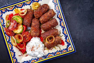 Traditionelle kroatische Cevapi als würzige Fleischbällchen mit Barbecue Gemüse und Zaziki...