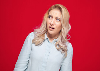 Suspect concept. Distrustful young woman, isolated on white background