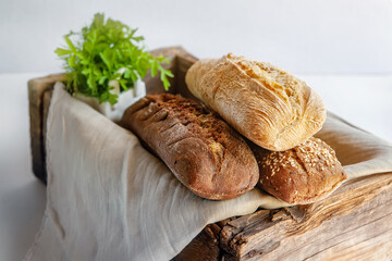 Assortment of bread in a wooden old rustic box. Various types of greens for bread. studio photo. Still-life.