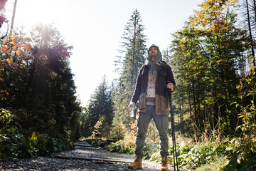 Male hiker is traveling at the mountains with backpacks exploring beautiful places of the natural park enjoying the outstanding landscape views.