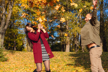 Lovely couple having fun together in nature. Boyfriend carrying his girlfriend in his arms.