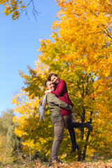 Lovely couple having fun together in nature. Boyfriend carrying his girlfriend in his arms.