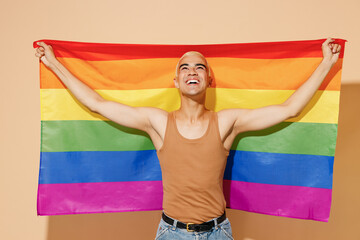 Young activist overjoyed smiling fun blond latin gay man with make up in beige tank shirt hold...