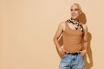 Young smiling happy trendy fashionable stylish blond latin gay man 20s wear beige tank shirt neck...