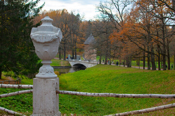 An old flowerpot with a tower and a bridge in the background. Autumn Park.