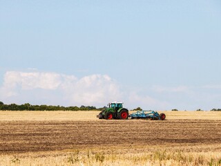 Tractor with disc harrow working in the field.