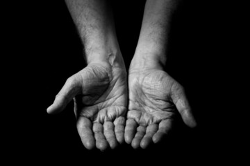 Male hands held out, with palms up begging.