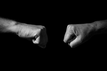 Male hand held out, with clenched fists for fist bump.