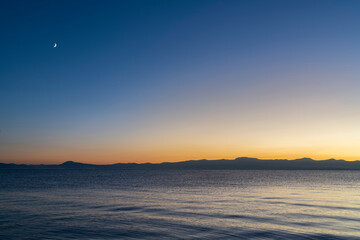 Beautiful landscape after, moon above the lake and mountains.