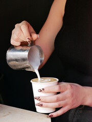 Barista with long nails Pouring latte Art into white paper cup takeaway