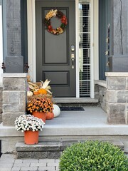 Colourful pumpkins, gourds and mums create a luxury thanksgiving landscaping decor at a front...