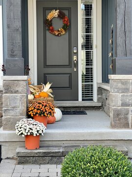 Colourful pumpkins, gourds and mums create a luxury thanksgiving landscaping decor at a front entrance.