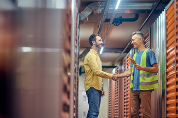 Two men shaking hands near warehouse garages