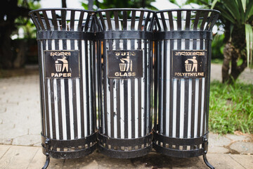 Three iron waste bins for separate waste collection - paper glass and polyethylene