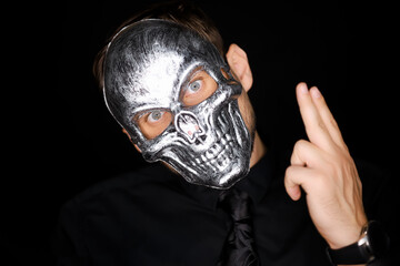 a man in a skeleton mask shows a variety of gestures with his hand