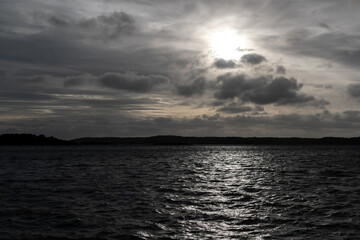 Naklejka premium Seascape with clouds. Shot into the sun. Dramatic and white light stylized.