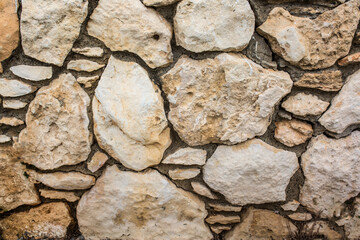 Obraz premium Stone antique old wall as a background or texture. Vintage background of a fortress wall in loft and grunge style with place for text and copy space.