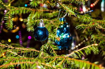 Christmas toys against the background of green branches and lights