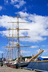 a historic sailing ship with three masts at the port berth