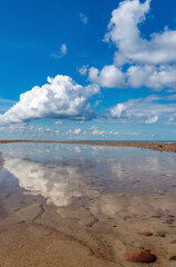 Obraz premium Reflection of clouds in the water. Beautiful sky. The sea coast. Deserted seashore.