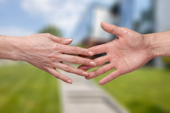 Hands of caregivers and the elderly human on a background