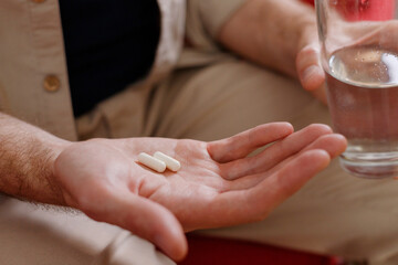 Close up of man hands taking medicines and supplements,