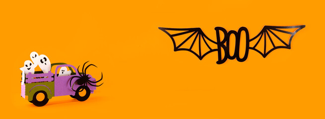 Happy halloween holiday concept. Halloween handmade paper decorations, spiders, ghosts in car, bats, boo text on orange background. Halloween festival party, banner, card mockup with copy space.
