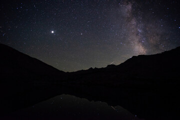 Milky way rising over Vogelsang Peak, reflected in Fletcher Lake, Yosemite National Park Tuolumne Meadows