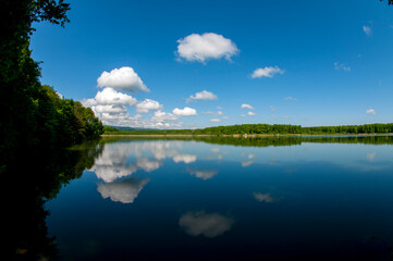 Naklejka na ściany i meble Beautiful panorama of autumn lake against the background of forest and sunny sky