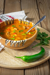 Romanian traditional beef soup served in clay bowl. In romanian is called "ciorba de vacuta".