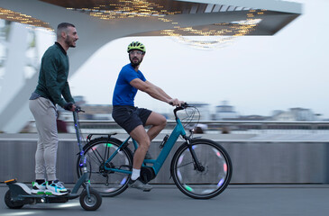 Men riding scooter and bicycle along urban waterfront