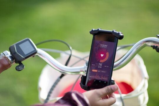 POV woman on bicycle checking heart rate with smart phone app