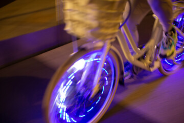 Man riding bicycle with purple lights at night