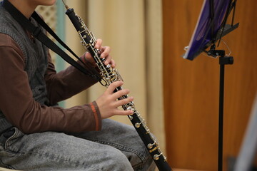 Person a young student studying music plays a musical instrument by notes