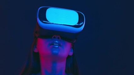 Augmented reality world. Excited asian lady in vr headset looking around, playing virtual video game in neon lights