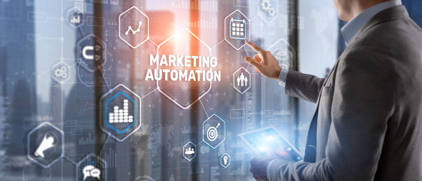 Marketing automation on the virtual screen. Man clicks on the inscription Marketing