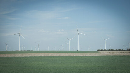 Clean green energy windmill turbine farm on rolling hills of Kansas