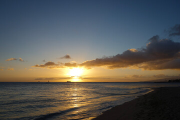 Orange Sunset with purple clouds over a scenic view of the Pacific Ocean off the coast of Waikiki Beach in Hawaii