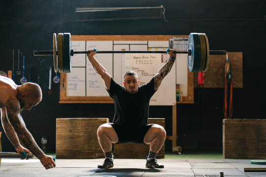 Strained weightlifter doing snatch exercise