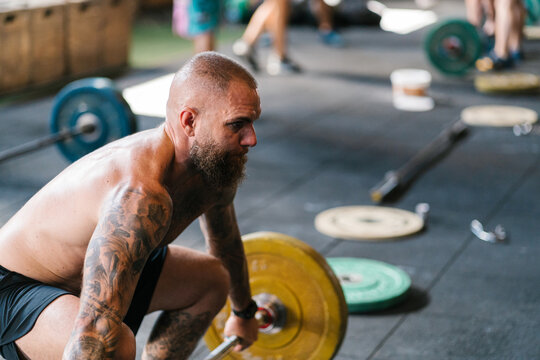 Tattooed man lifting a barbell
