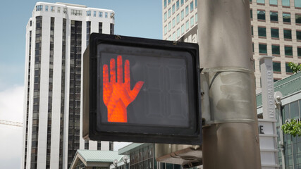Urban City pedestrian crosswalk safety sign signal with bright orange hand