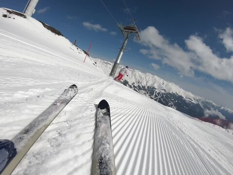 Close-up view of the skis sliding with great speed on the slope down wasted snow
