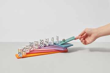 Woman pushing sphere on dominoes