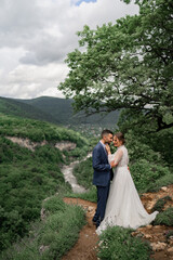 a beautiful hugging newlyweds in a wedding ceremony in the mountains