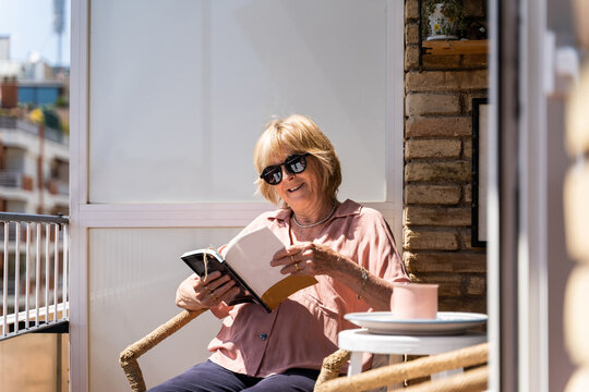 Senior woman hreading book in balcony at home