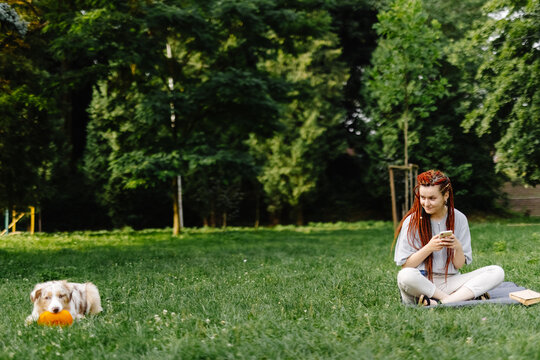 Woman spending free time in park with dog 
