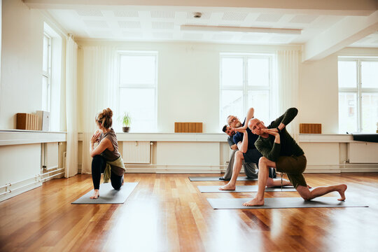 Yoga teacher leading male students in a class