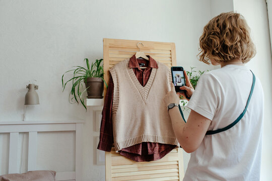 Woman taking picture of wardrobe for ad on internet 